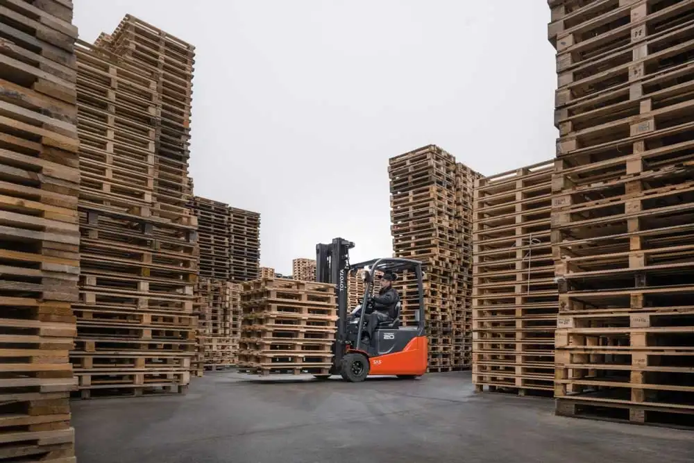 Autoelevador manipulando pallets de madera en un depósito